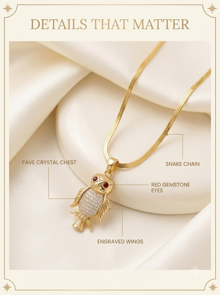 Athenis Owl Pendant detail: pave crystal chest, red gemstone eyes, engraved wings and snake chain