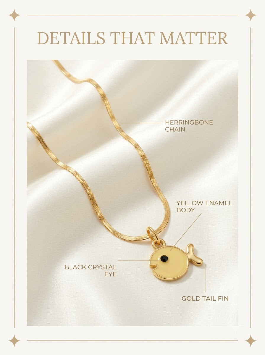 Soleia Fish Pendant detail: yellow enamel body, black crystal eye, gold tail fin and herringbone chain