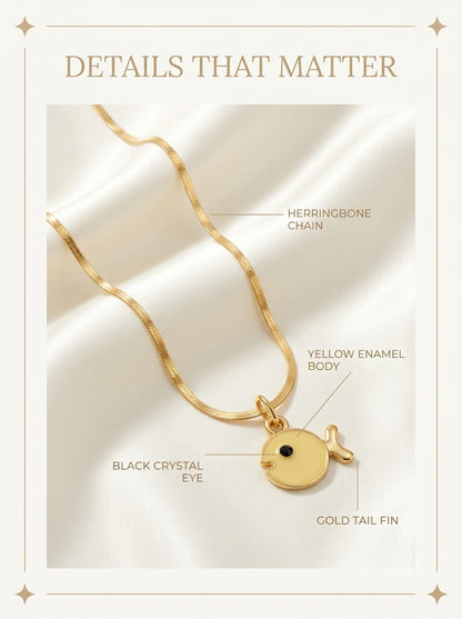 Soleia Fish Pendant detail: yellow enamel body, black crystal eye, gold tail fin and herringbone chain